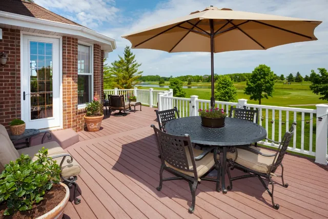 Composite deck with white railing, patio umbrella and dining set