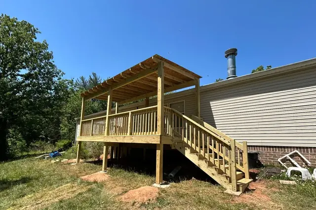 New pressure-treated elevated deck with pergola roof and long staircase