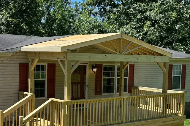 Covered front porch with timber gable roof and wood railings