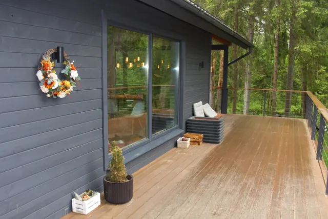 Modern wood deck along a gray-sided home with cable railing